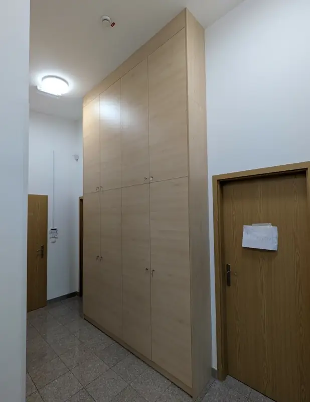Visoka omara po meri z osmimi vrati in ključavnicami v hodniku poslovnega prostora