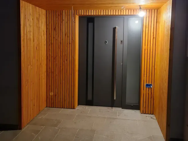 Vhod, obložen z lesenimi lamelami iz macesna